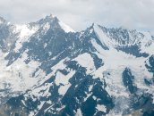 Hohsaas  Die Mischabelgruppe: T�schhorn, Dom, und Lenzspitze (mit Schneefeld auf der rechten Flanke). Zwischen dem Ulrichshorn ganz rechts und dem in den Nebel hineinragenden Nadelhorn f�llt der Hohbalmgletscher ins Tal ab. Der Dom ist mit 4545m der h�chste ganz auf Schweizer Boden stehende Berg.